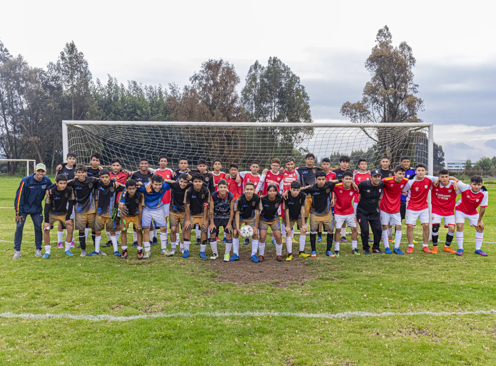 Foto grupal de The Gunners junto a otro club en la cancha